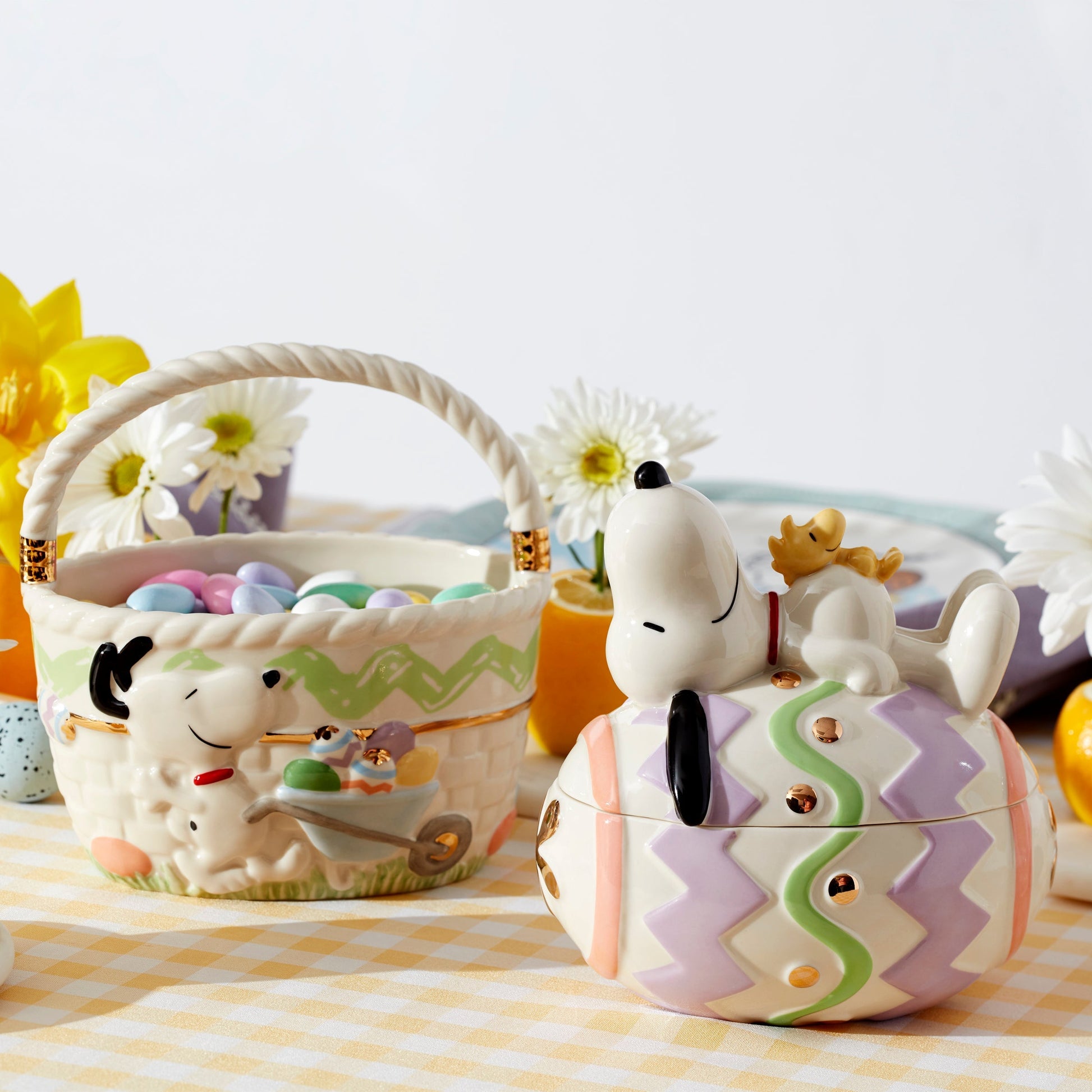 Snoopy-themed Easter basket and cookie jar on a checkered tablecloth with flowers in the background.